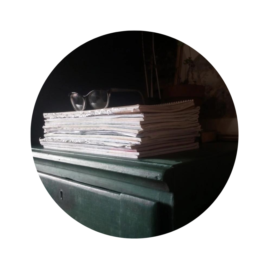 A circular photograph showing a stack of notebooks and a pair of reading glasses. Though they do their copy editing and proofreading online, L.B. Hazelthorn is an old-fashioned creature who takes notes by hand. This image is both aesthetic and accurate, how satisfying!